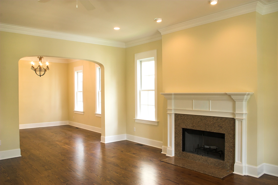 empty living room with granite fireplace and windows